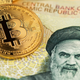 A few gold coins with the bitcoin symbol sitting atop Iranian currency with Ayatollah Khamenei's face.